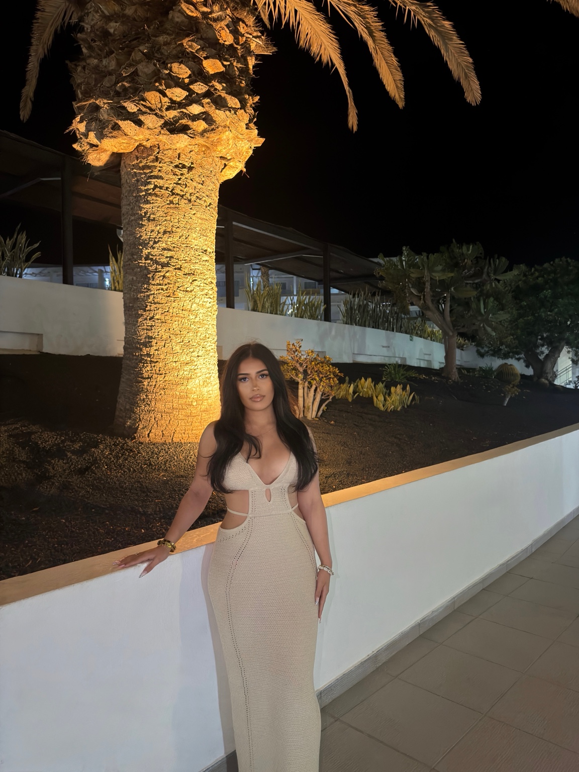 Mila in a white dress under palm trees